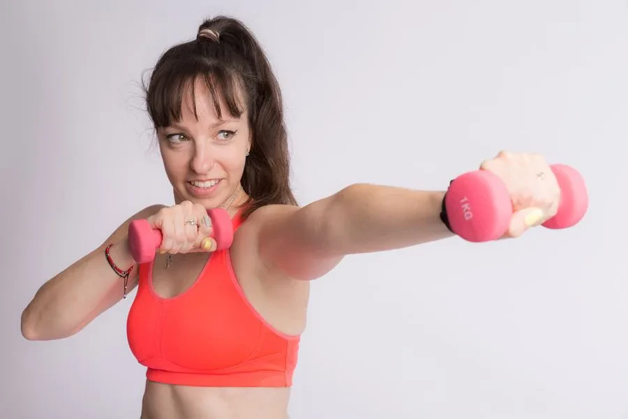Tina beim Training mit zwei pinkfarbenen Hanteln